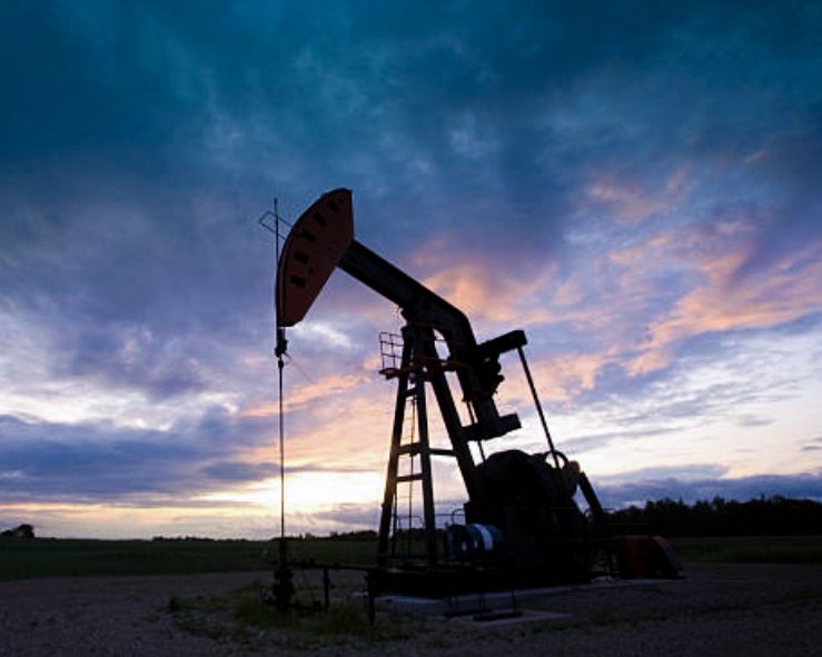 Oil pumpjack silhouetted against an evening sky