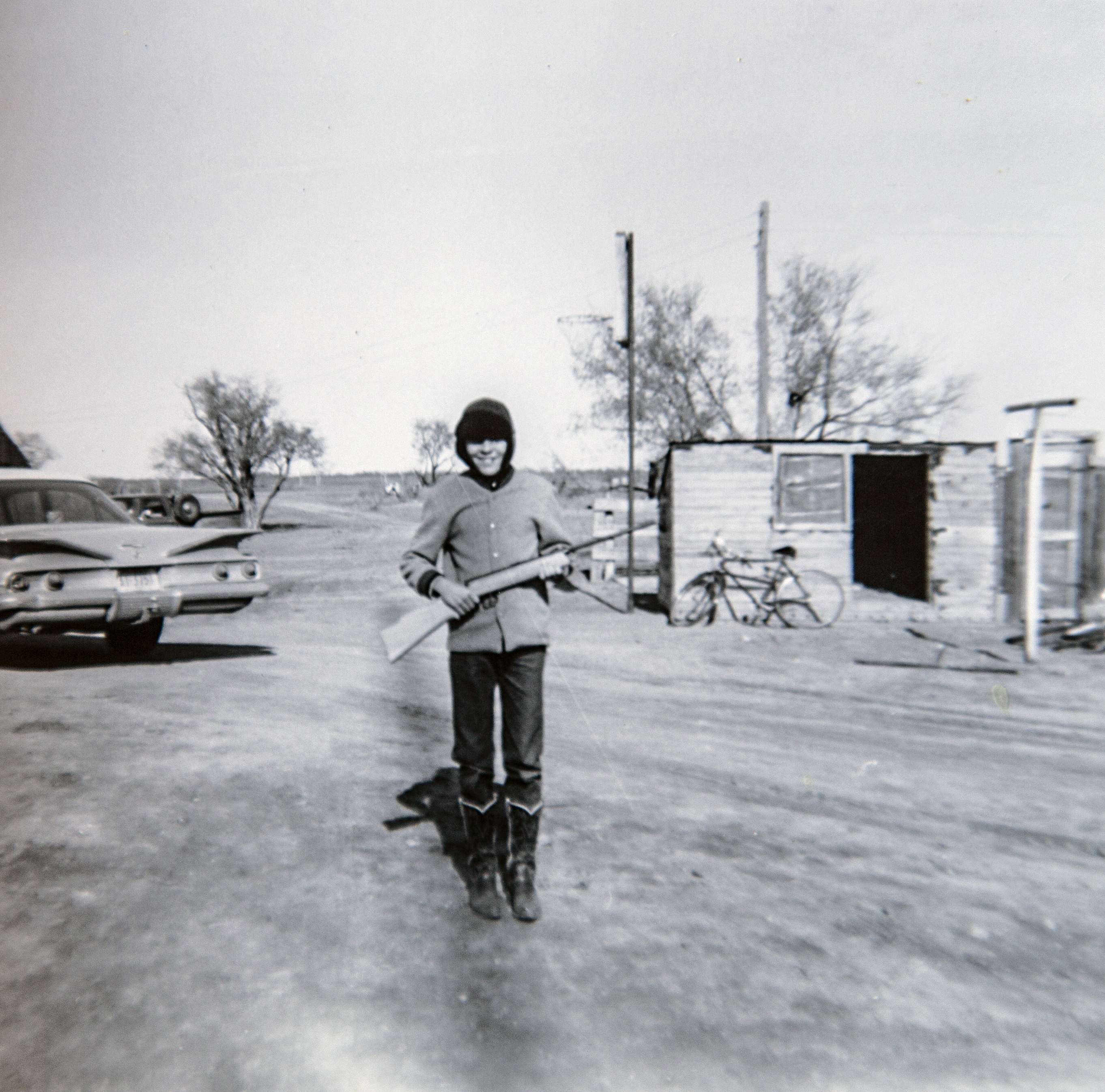 young boy standing with a rifle