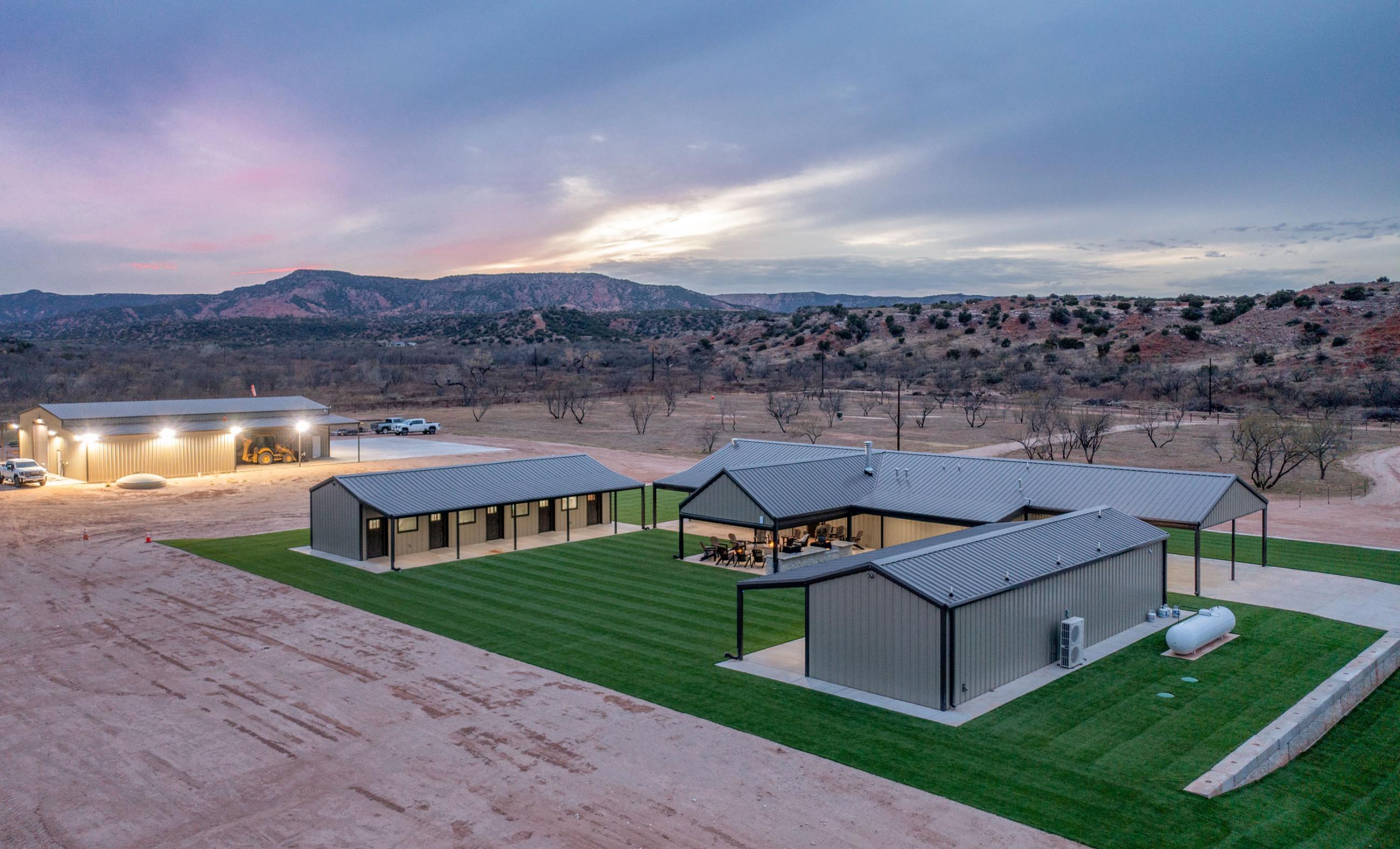 Ranch headquarters buildings with canyon hills at dusk