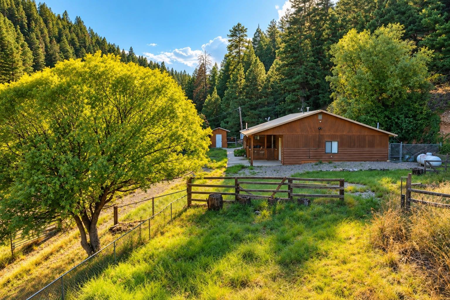 Cabin and fenced grounds in a wooded setting